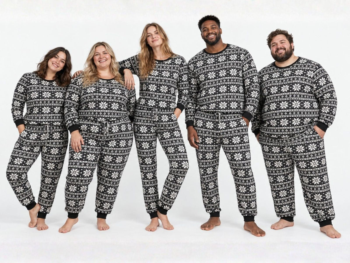 Five adults of different heights and sizes in matching Baby It's Cold Outside black-and-white fair isle pajamas