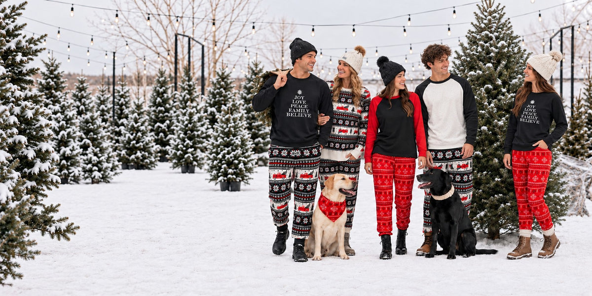 Friends and family in matching Black Sheep Fam holiday pajamas with two dogs at a snowy tree farm