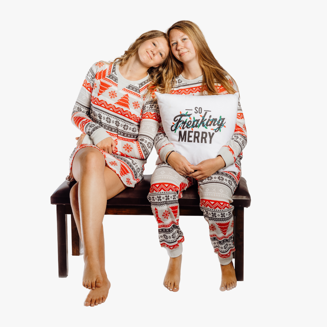 Women wearing Nordic Fair Isle sitting on bench with So Freaking Merry pillow