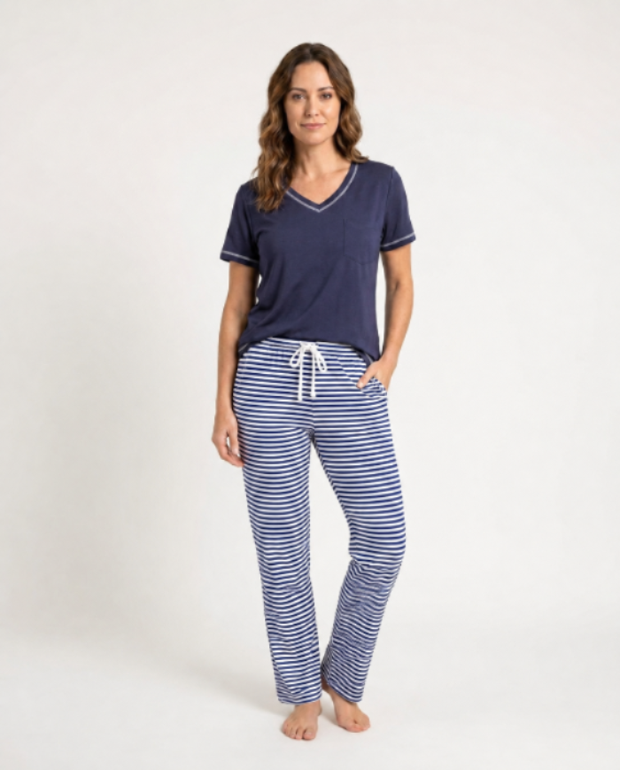 Woman wearing a navy blue top and striped pants on a white background