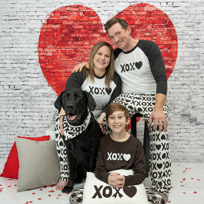 Family wearing XOXO shirts and pants with dog in bandana
